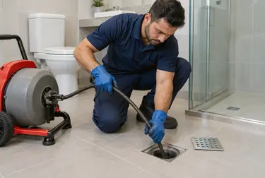 Profissional utilizando ferramentas para desentupir ralos.